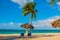 Playa Esmeralda, Holguin, Cuba. Caribbean sea: two sun loungers, umbrella, palm tree on the beach, on the background of the turquo