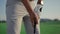 Player hold golf putter club on golfing game. Man play sport activity on course.