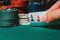 Player reveals one pair of aces in poker against the background of playing chips on the green table