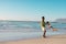 Playful african american young father spinning son at beach against clear sky during sunset