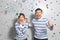 Playful Asian couple being happy and amazed on grey studio background