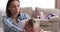 Playful baby girl with mother taking selfie using phone at home