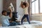 Playful biracial dad and little daughter engaged in pillow fight