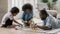 Playful biracial dad play with two children at home