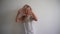 Playful blond girl with wet hairs after bath pose on white wall. Gimbal motion