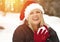 Playful Blonde Woman In Santa Hat Making Snowballs Outdoors