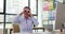 Playful businesswoman sits at table and looks at roll of paper through binoculars