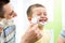 Playful child and father shaving together at home bathroom