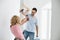 Playful couple fighting while painting new house