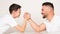 Playful dad and son compete in arm wrestling