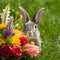 Playful Easter Bunny peeking out from behind a vibrant floral arrangement