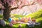 A playful Easter card concept with a group of colorful, cartoon-style Easter eggs having a picnic under a cherry blossom tree,