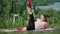 Playful Fat Man with Long Hair Does Gymnastics for Weight Loss Outdoors. Funny Overweight Guy Depicting a Girl Engaged In Fitness