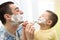 Playful father and his son shaving in bathroom