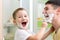 Playful father and kid son shaving and having fun