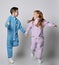 Playful frolic kids boy and girl in blue and pink jumpsuits with are running together looking at each other