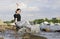 Playful girl sitting on rocks on the river Bank