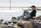 Playful girl sitting on rocks on the river Bank