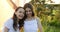 Playful girls hugging on summer nature at countryside. Smiling girl friends embracing on tent background.