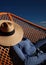 The playful interaction of light and shadow on a model's face, cast by a lattice wearing a wide-brimmed hat in