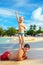 Playful kid pretending he is Statue of Liberty, with father on tropical beach