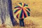 Playful little child hiding behind colorful umbrella