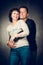 Playful mature married couple photographed in the studio. Handsome man in jeans and smiling woman in shirt playing.