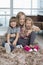 Playful mother with children sitting on rug in living room