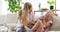 Playful mother tickling daughter on sofa at home