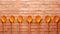 Playful Orange Spoons Against Brick Wall: A Vibrant Composition