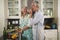 Playful senior couple enjoying while cooking in kitchen