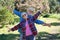 Playful senior couple walking in the forest with arms outstretched. Two happy retired enjoying healthy lifestyle and nature