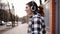 Playful, smiling girl in a shirt walking on the street and moving in dance. Funny funky style. Headphones. Expression
