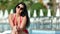 Playful sunny lady in red swimsuit lounging on deck chair at spa resort feeling happiness