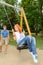 Playful teenage couple girl on swing