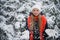 A playful teenage girl with a beautiful smile throws snow flakes and rejoices at the onset of the long-awaited winter.