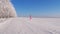 Playful Woman Running And Spinning In Winter On Snow In Field, Hands In Side.