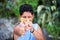 Playful young boy aiming a catapult at the camera