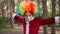 Playful young guy with clown wig on his head and medical mask on his face funny dancing. Coronavirus and pandemic. Quarantine