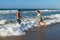 Playfull young couple in bikini and shorts at the beach.