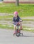 On the Playground the child rides the girl on the bike.