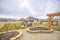 Playground and patio at the grassy yard of a home with wooden pergolas