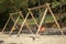 Playground swing. Wooden poles and plastic seats.