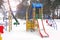 Playground in the winter. Children`s playground in the snow. Children`s swing
