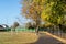 Playground with yellow autumn trees and treadmill strewn with foliage