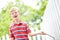 Playing in the backyard. A cute young boy running a stick along a white picket fence in his backyard.