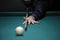 Playing billiard. Player arm gets ready to stroke a ball with a cue