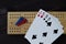 Playing cards and cribbage board on black background