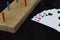 Playing cards and cribbage board on black background