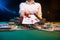 Playing in a casino, online casino. A player opens cards with two aces. Money, poker table, chips. Background for the gaming